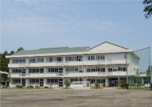 清原北小学校の外観写真　緑色の屋根の白い3階建ての校舎