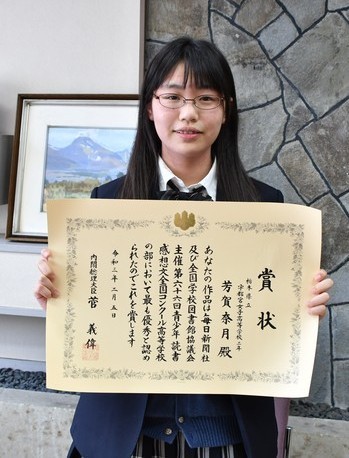表彰状を持つ芳賀さんの写真